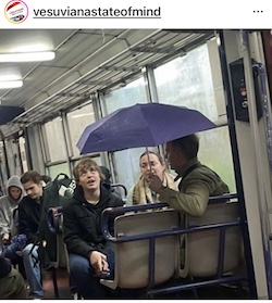 Piove nel treno Circumvesuviana, turisti con ombrello aperto